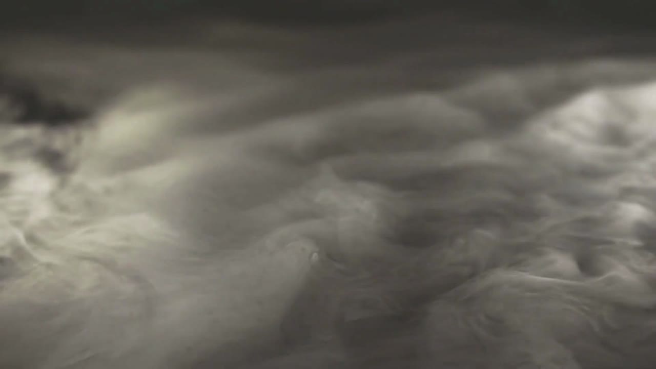 View of swirling, smoke clouds against a black background.