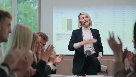 business and motivational training charismatic female speaker is standing against display chart