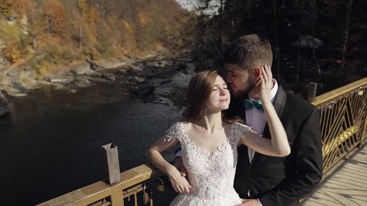Romantic Wedding Couple Kissing on Bridge