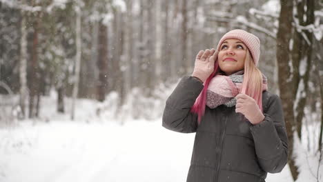 Outdoor-close-up-portrait-of-young-beautiful-happy-smiling-girl-wearing-white-knitted-beanie-hat,-scarf-and-gloves.-Model-posing-in-street.-Winter-holidays-concept.