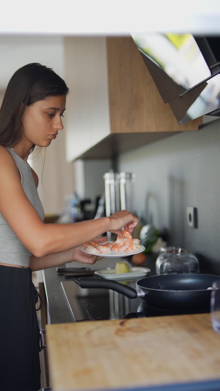 mujer cocinando camarón en una cocina