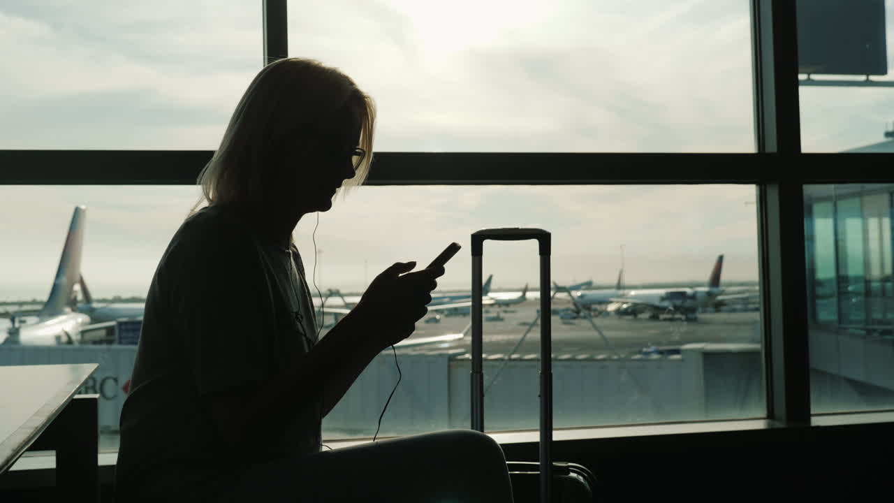 mujer con maleta usa teléfono en aeropuerto