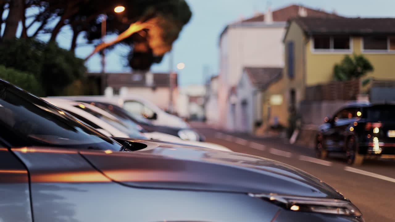 Close up of cars parked on the side of the street in Nice, France in the evening