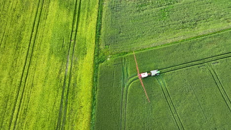aerial view of a tractor spraying crops in a green agricultural field