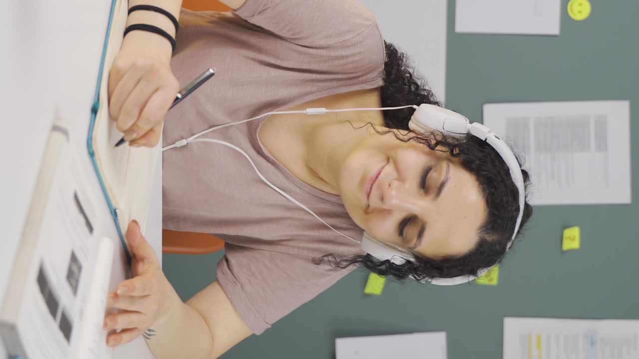video vertical de una estudiante feliz escuchando música.
