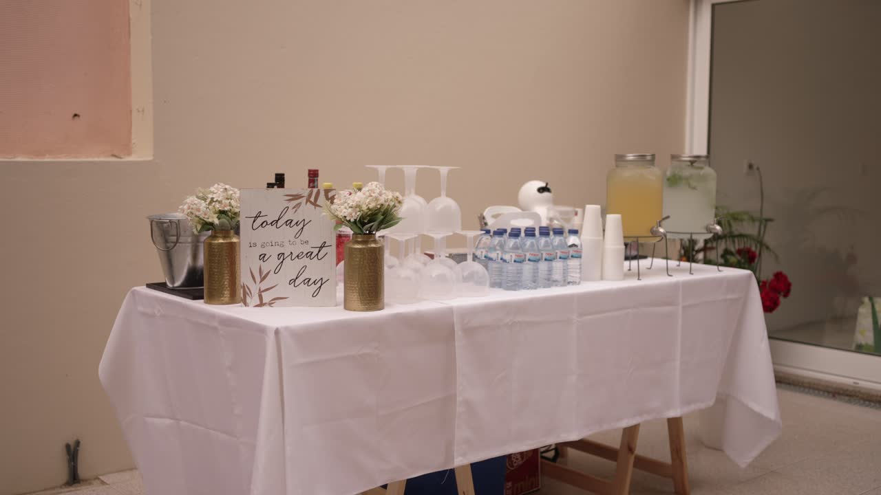 drink table with lemonade water bottles and flowers ready for event