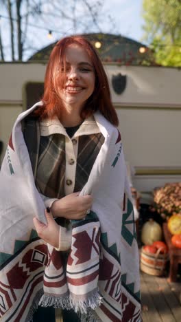 happy woman enjoying a cozy autumn day by a camper van