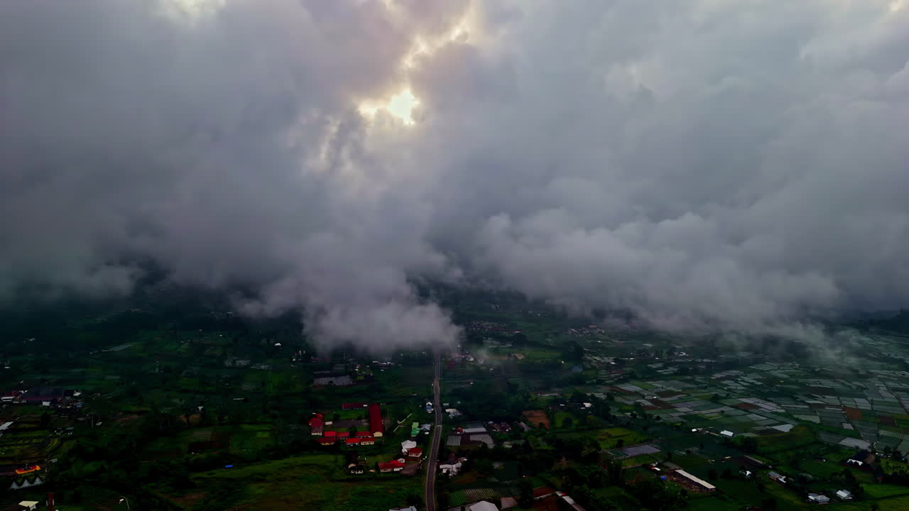 Morning fog over lush farmland and road in Bukit Selong, Bali, Indonesia