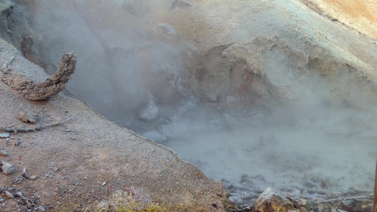 Pozza di fango geotermica fumante con attività vulcanica ribollente nel Parco Nazionale Vulcanico di Lassen, California, USA, con vapore solforoso che sale da un bacino idrotermale naturale e terreno ricco di minerali.