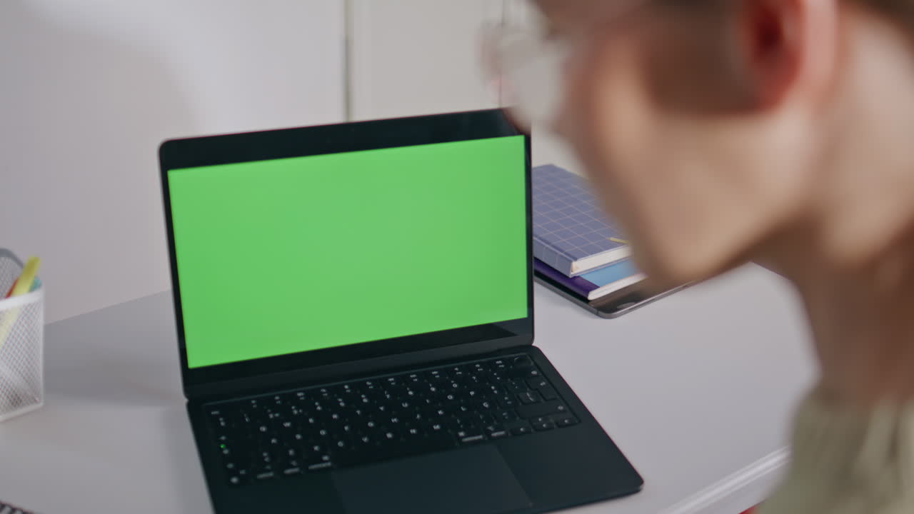 Lady teacher looking greenscreen laptop in school office closeup. Online lesson