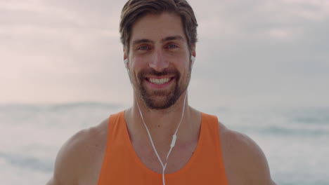 retrato de un joven musculoso sonriendo feliz disfrutando de un estilo de vida saludable con auriculares en una hermosa playa real