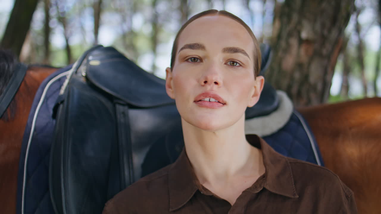 Closeup gorgeous horsewoman posing at summer woodland. Woman looking camera