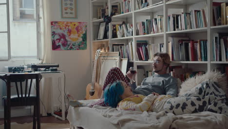couple chilling on bed, bonding and having wine