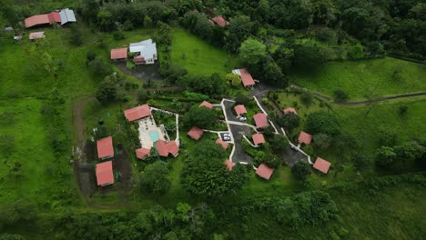 Bird’s-eye-view-moving-forward-shot,-houses-in-the-foothills-of-The-La-Tigra-Rain-Forest-in-Costa-Rica