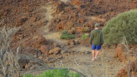 Dangerous-hiking-trail-of-red-rock-in-Teide-national-park,-man-walks-in