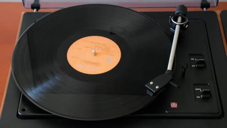 woman hand starting the retro-styled vinyl record player