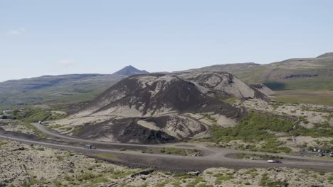 looking across a road in iceland at the large gradbrok crater as it sits dormant near bifrost in the nordurardalur valley