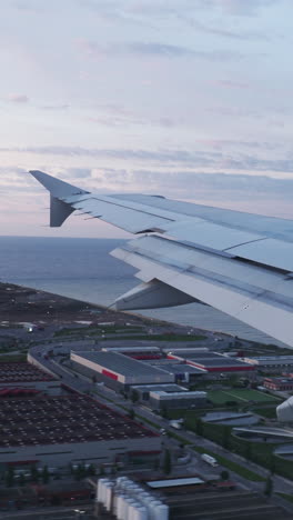 view from a plane window during landing into barcelona airport in shot in vertical