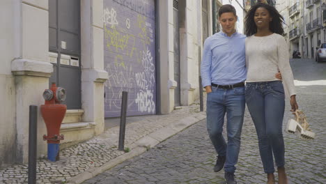 happy young couple strolling on paved street.