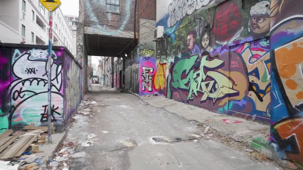 camminando lungo un vicolo nel centro di toronto con graffiti sui muri