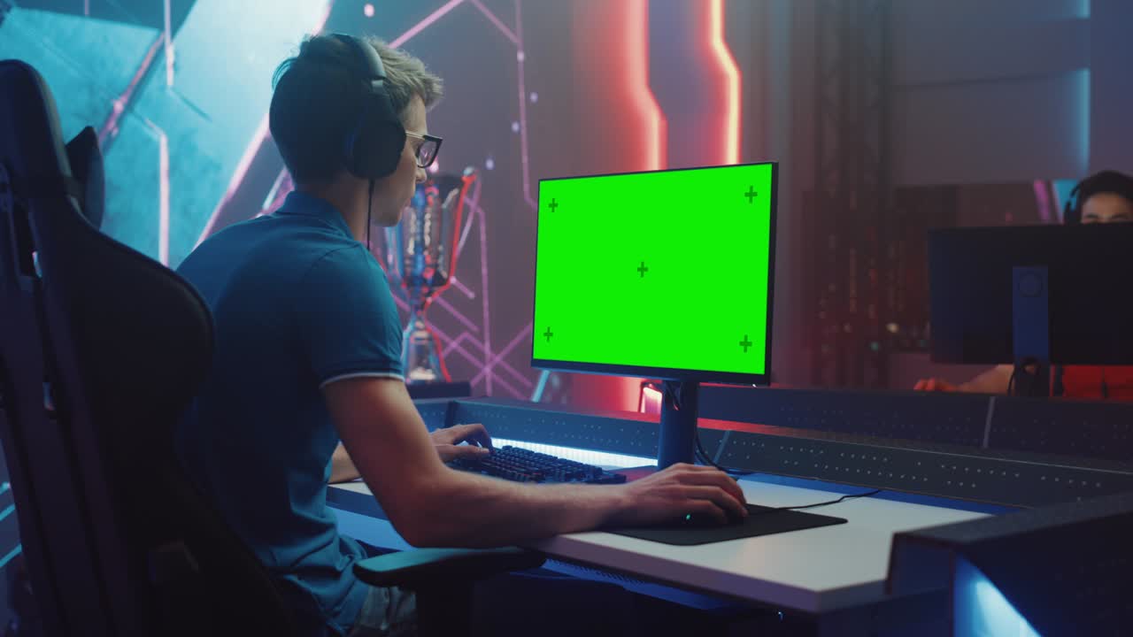 sul campionato di videogiochi professionista di esports gamer gioca su green chroma key screen computer personale. live streaming online torneo di cyber gaming stanza elegante. arco laterale scatto medio