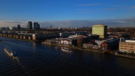 ships passing on ij river next to amsterdam noord vogelbuurt drone fixed shot