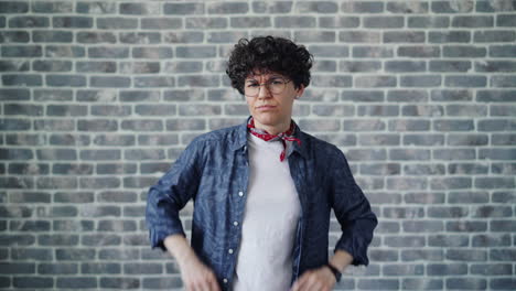woman expressing frustration or confusion in front of a brick wall