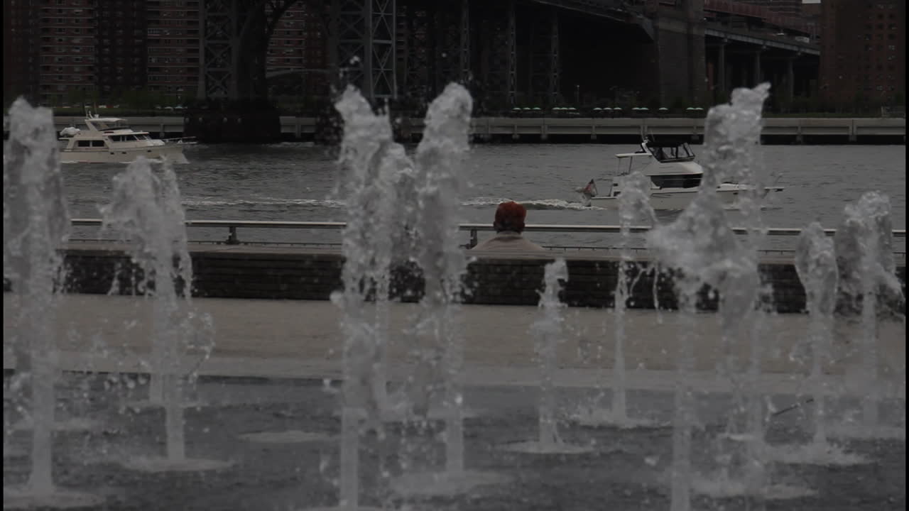 City Riverfront Fountain with People and Boats