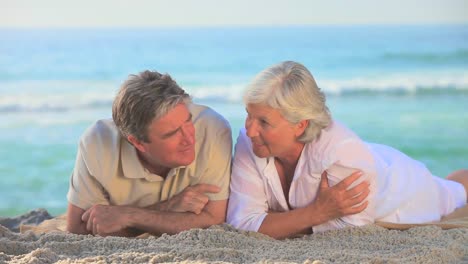 pareja de ancianos acostada en una playa