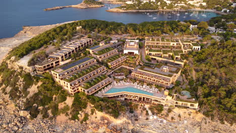 aerial view of luxury hotel and resort on shore of balearic sea in ibiza, spain.