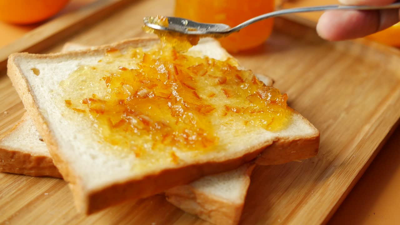Orange fruit spread on a bread on table ,