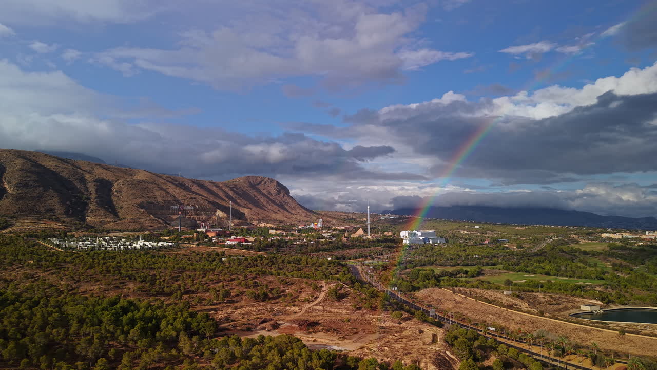 Vista aerea dei dintorni di Benidorm con montagne, autostrada, paesaggio verde e arcobaleno dopo la pioggia nella Spagna mediterranea.