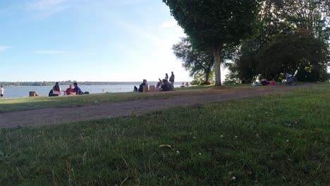 english bay park at the foot of stanley park, groups of people gather for a picnic suntanning lounging drinking playing while ignoring pandemic restrictions at vancouver canada on a hot summer day 1-2