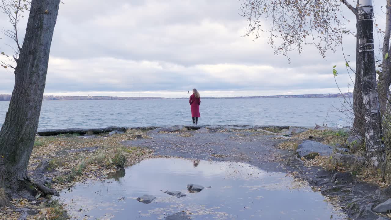 가을에 호수 에 은 코트를 입은 여자