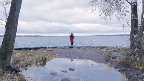 woman in red coat by the lake in autumn