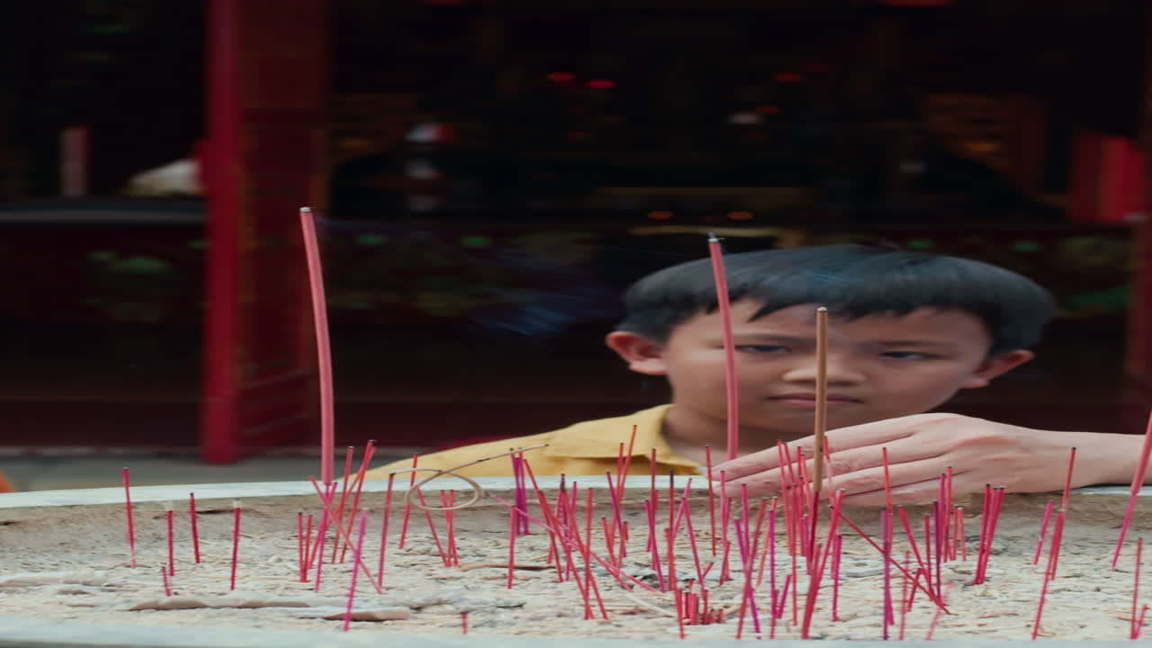 Family of Three Meditating near Altar with Sticks