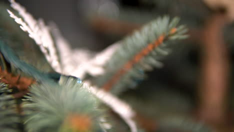hoja de árbol de navidad con adornos y alambre de iluminación, enfoque selectivo