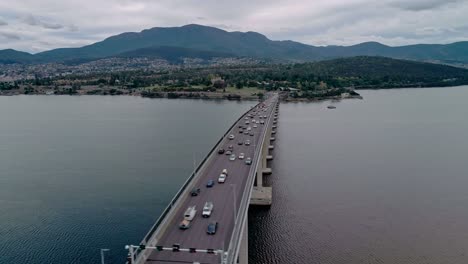 Aerial-view-of-a-busy-bridge-with-cityscape-at-background