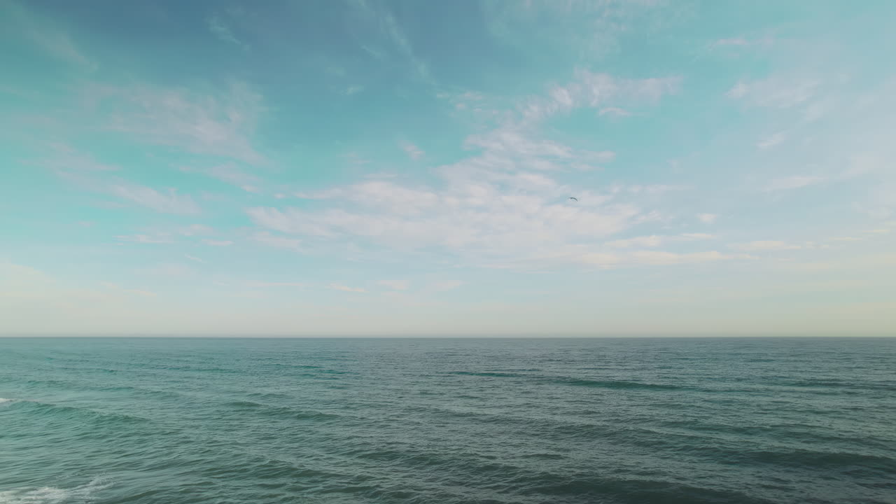 배경 에 산란 한 구름 이 있는 바다 파도