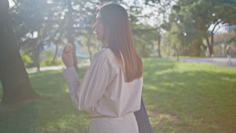 아름다운 방황객이 공원을 산책하며 아침 빛을 즐기고 있다. 웃는 여자