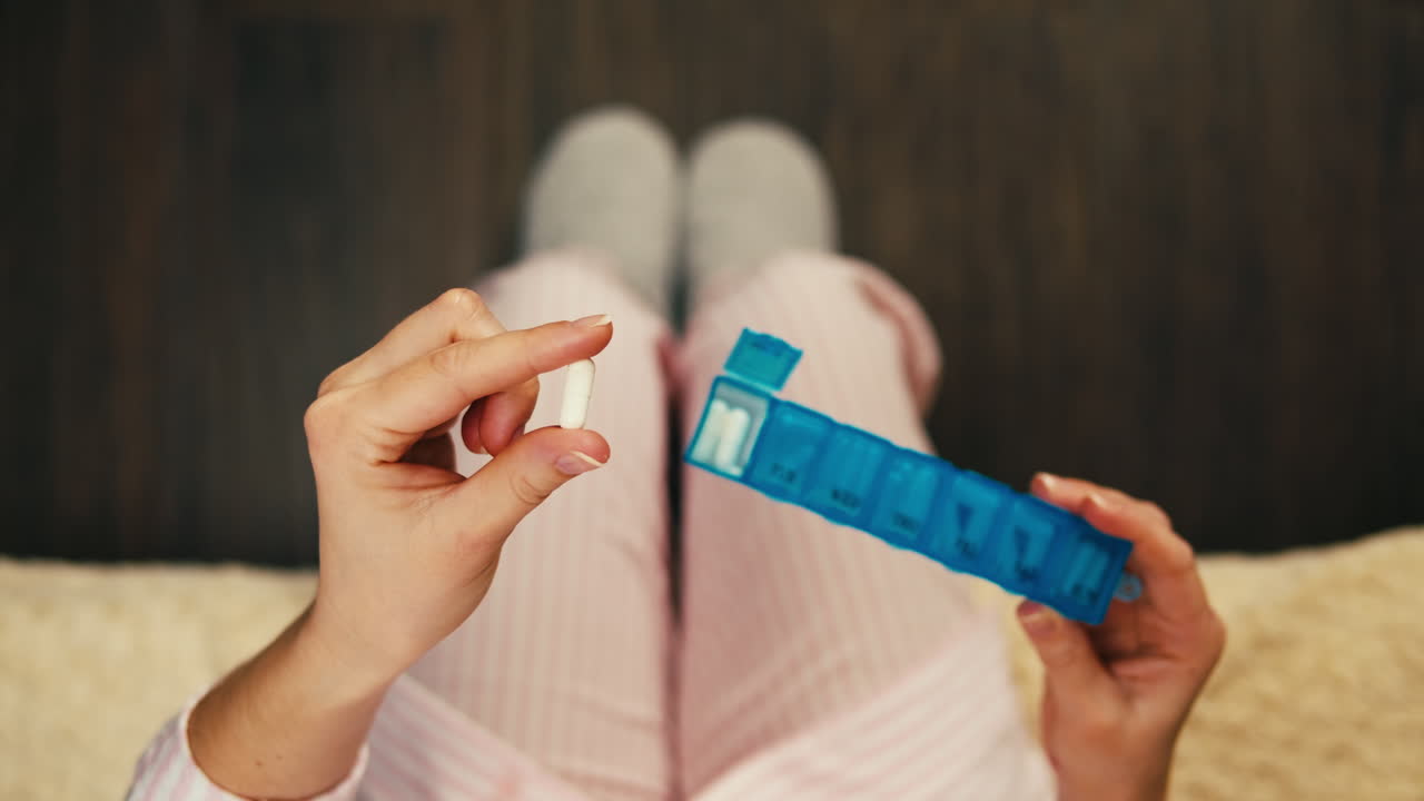 mujer tomando pastillas con organizador de pastillas