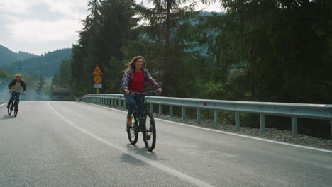 bicyclists riding mountain road. happy couple training bike on hiking outdoors.