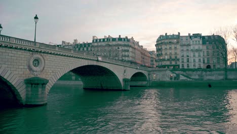 Louis-Philippe-Bridge-over-the-Seine-River,-with-Parisian-architecture-in-the-background-in-the-autumn-sunset