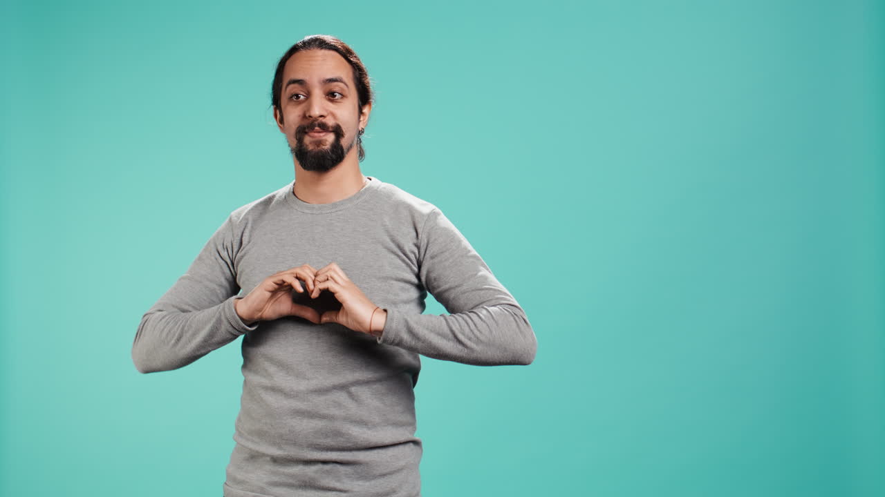 Persona sorridente che mostra il simbolo della forma del cuore con il gesto delle mani