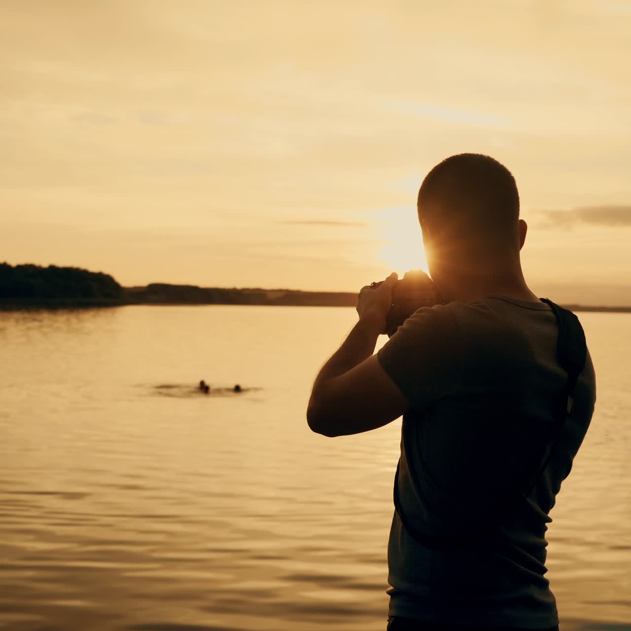 Photographer taking picture of sunset at local beach which is tourists point. Beautiful summer sunset