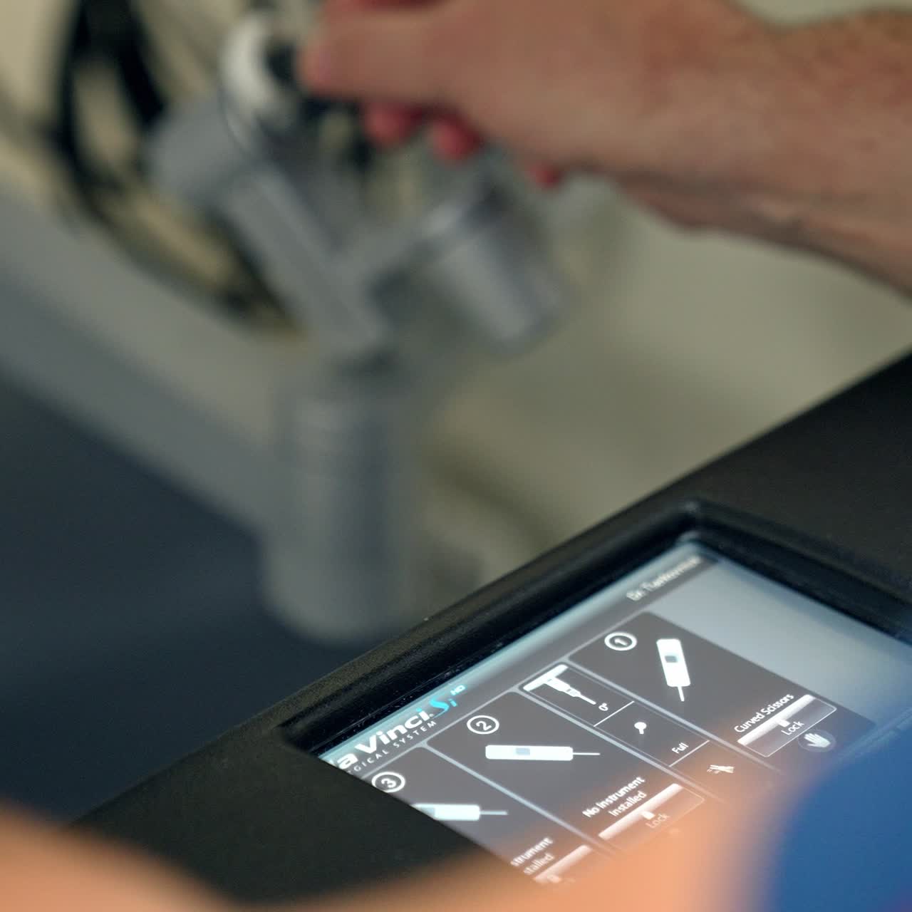 Sensor screen with keyboard of robotic machine. Male hands of a doctor operating the futuristic Da Vinci robot. Close up