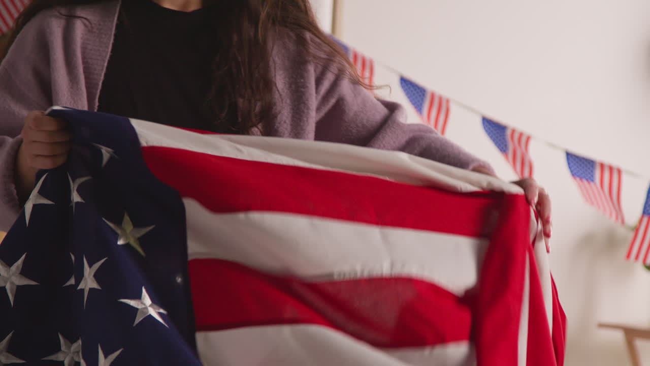 Woman At Home Putting American Stars And Stripes Flag On Sofa For Party Celebrating 4th July Independence Day