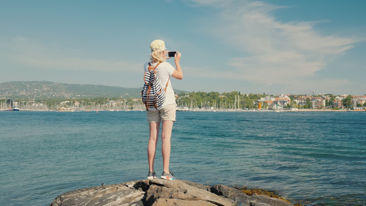 한 여성이 노르웨이 오슬로 시의 전경을 촬영하고 있습니다.