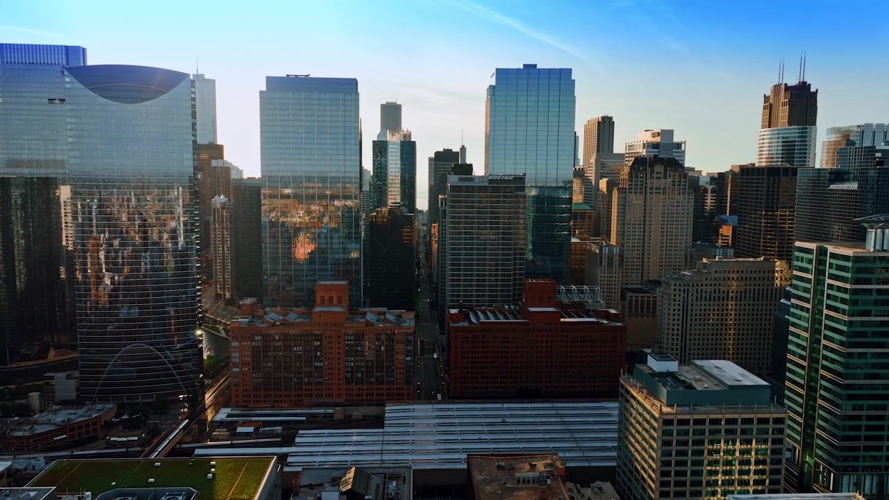 Avvicinandosi alle facciate a specchio dei grattacieli nel centro di Chicago. Il paesaggio urbano soleggiato si riflette nelle finestre.