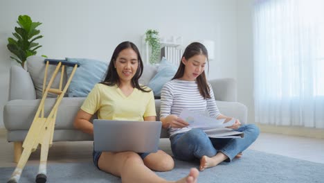 two women collaborating on documents at home